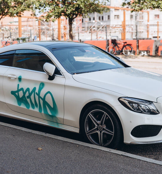 Copenhagen, 14 September 2020 - White Mercedes Benz vandalised by green spray paint parked at street in Copenhagen.